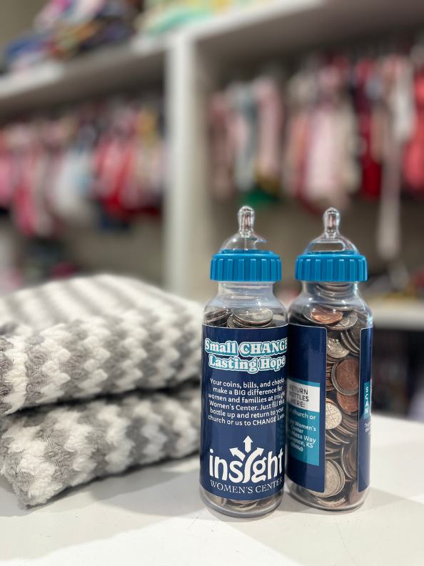 Two Small Change, Lasting Hope baby bottles filled with coins in the Insight boutique
