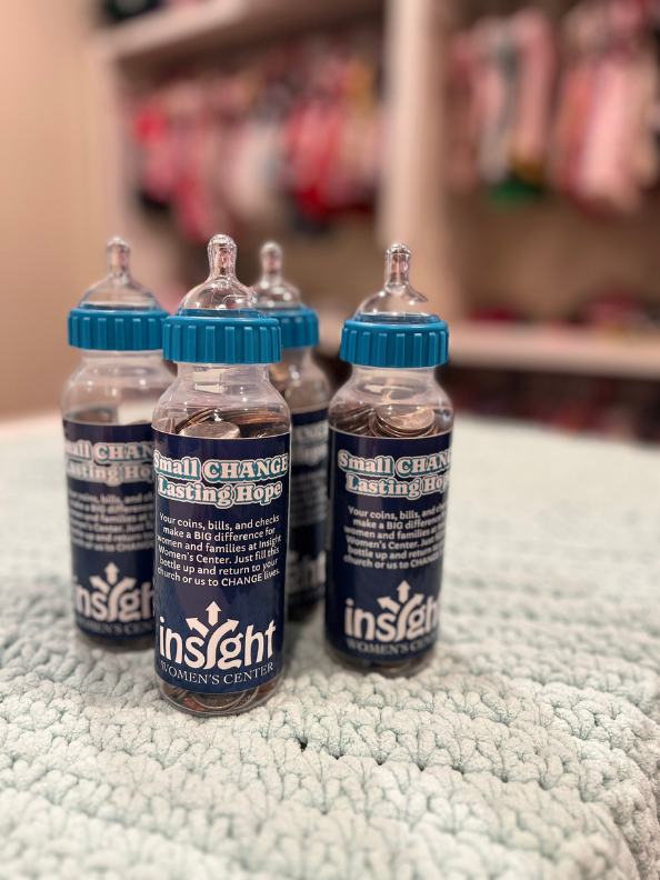 A cluster of Small Change, Lasting Hope baby bottles filling with coins
