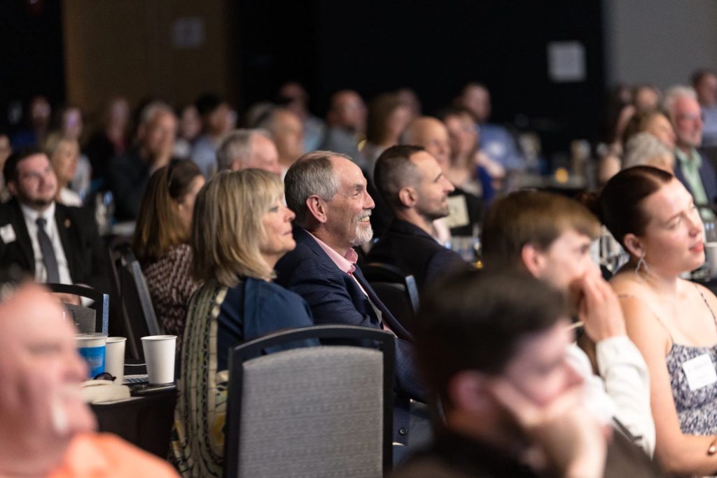 Guests smiling as they listen to the program